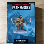 D&D Frameworks Dwarf Barbarian miniature in box by WizKids, featuring a detailed figure with axes against a blue icy backdrop.